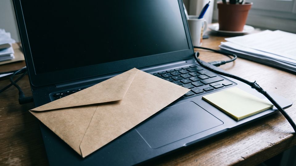 Enveloppe kraft posée sur un clavier d'ordinateur portable, lumière froide de fenêtre